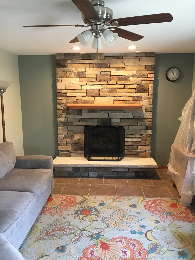 A stone fireplace with a new gas unit in a Chicagoland living room