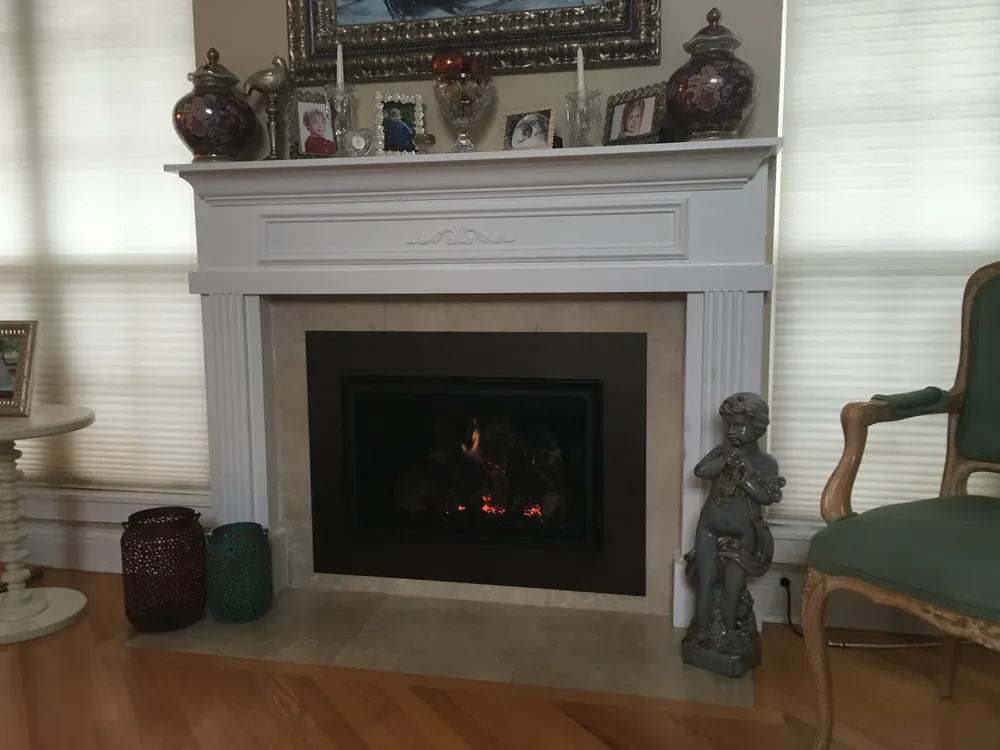 A gas insert burning in a classic white mantel