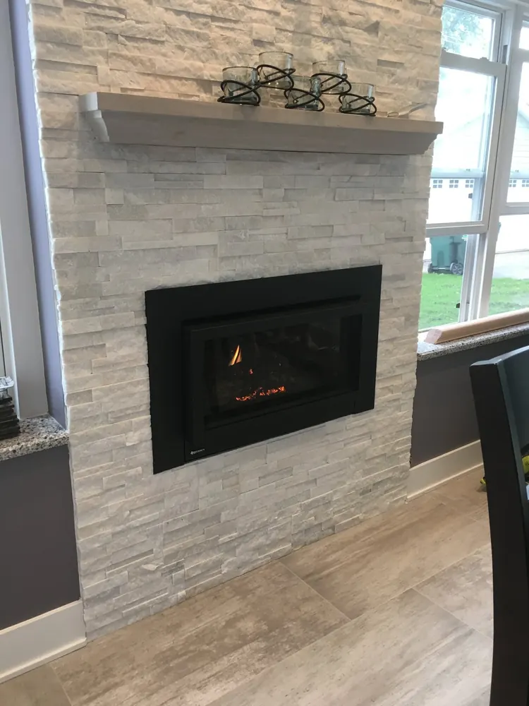 A gas insert burning in a ledgestone chimney breast — a recent Chicagoland house call