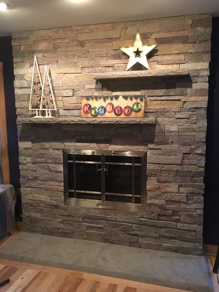 A stacked-stone fireplace wall with a wood mantel — one of our Chicagoland installs