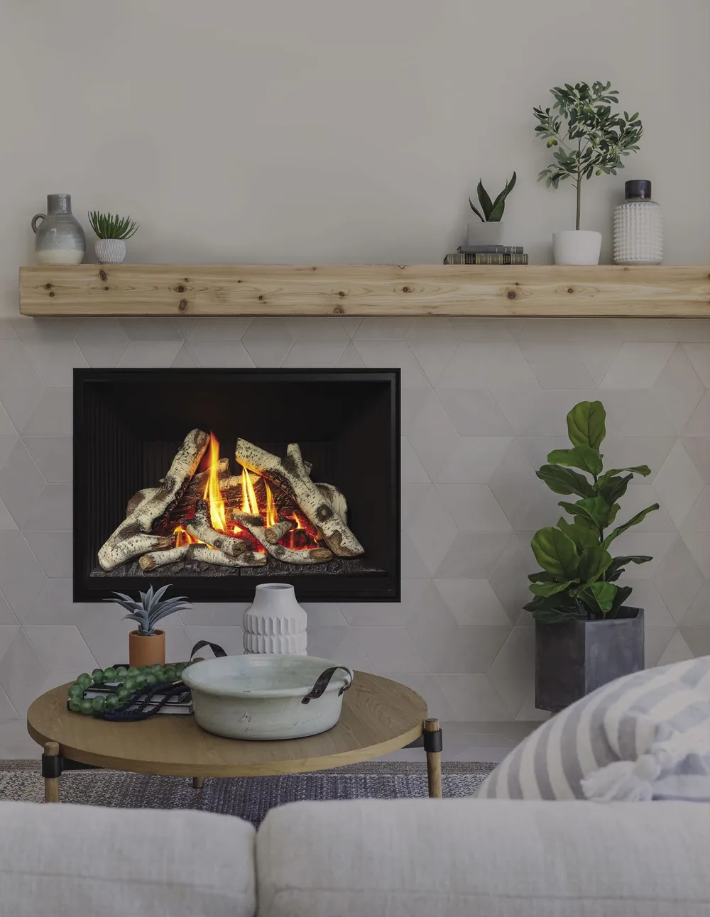 A Valor gas fireplace with birch logs burning beneath a wood mantel